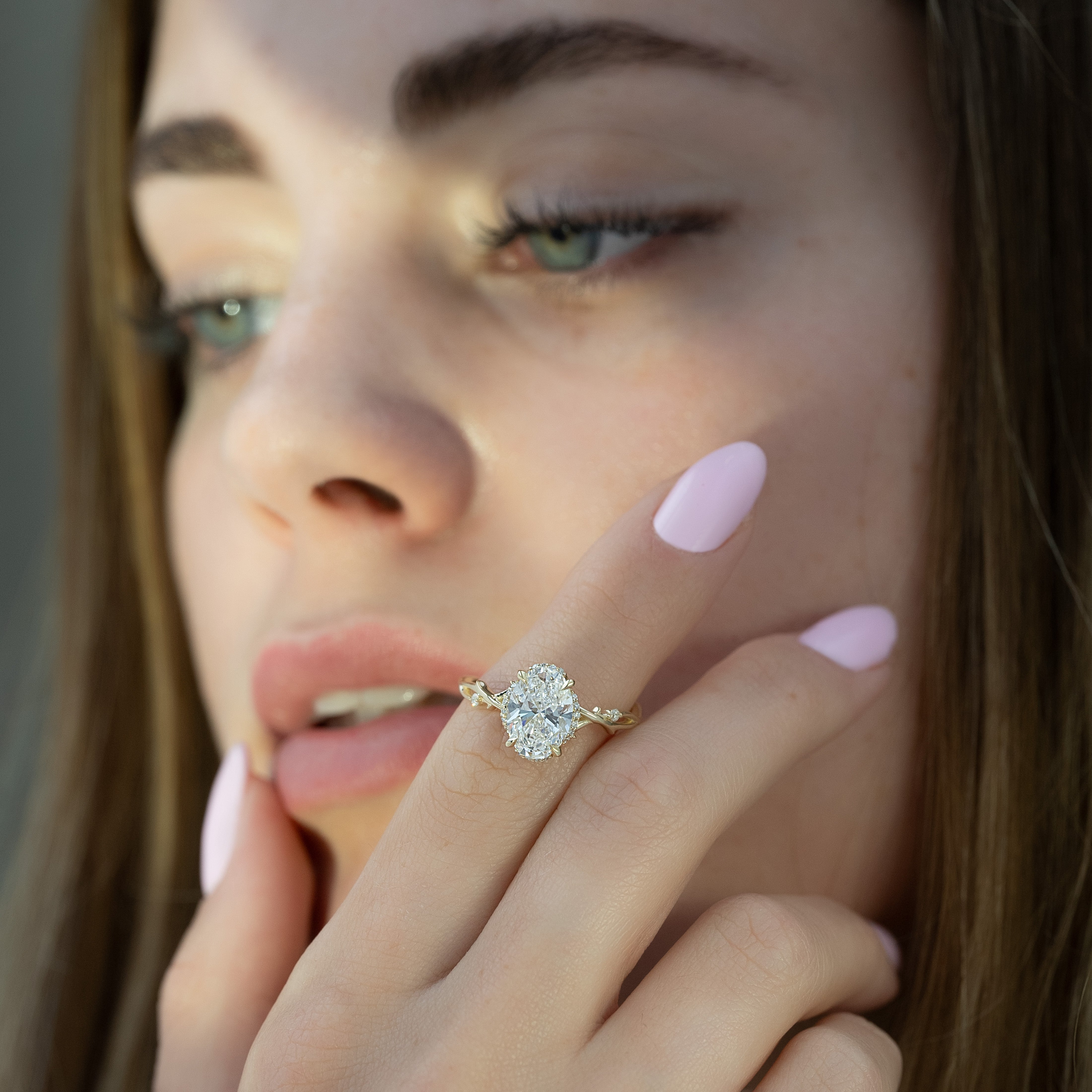 Aurora Halo 1.50 Carat VVS1 Lab‑Grown Oval Halo Engagement Ring in 18K Yellow Gold Hand View