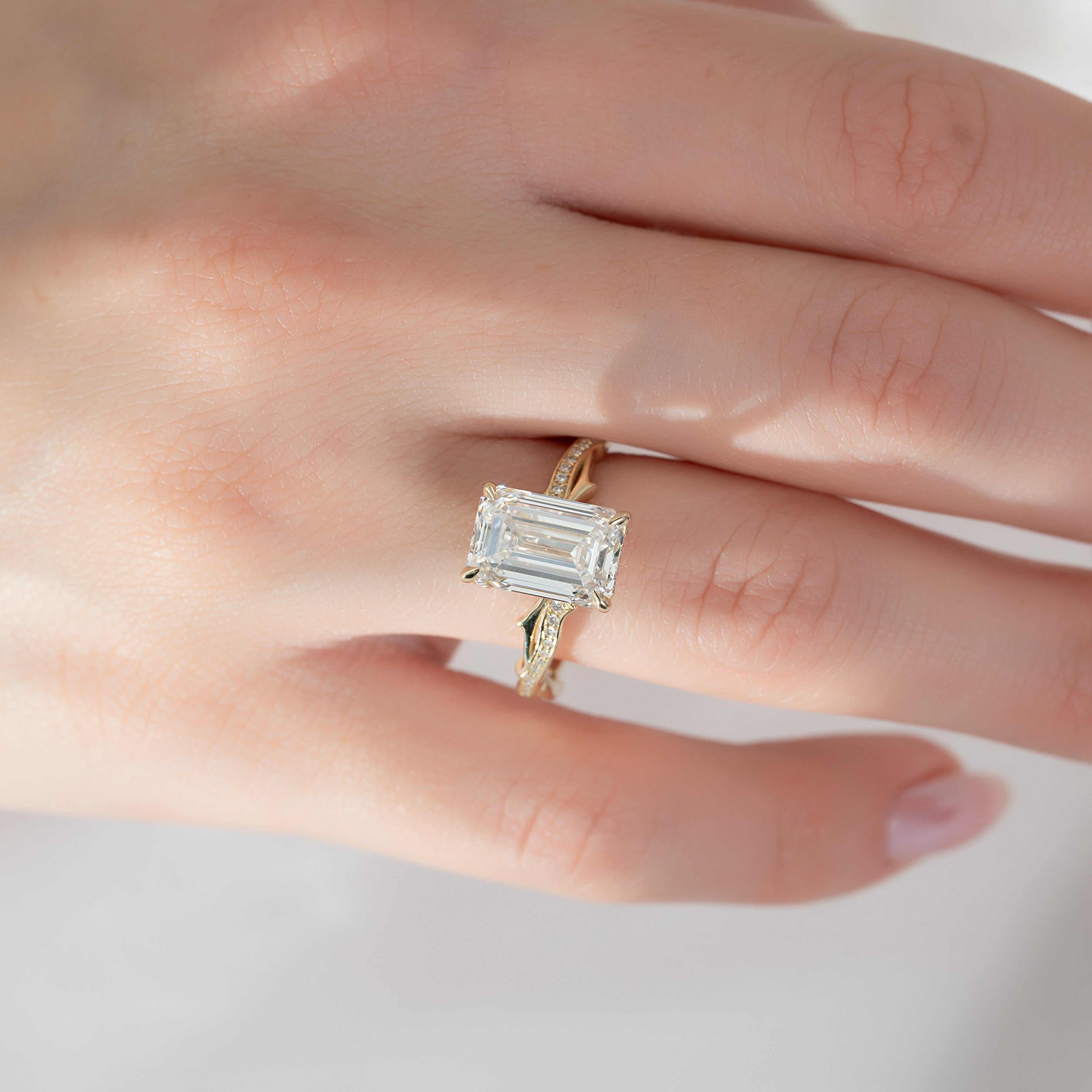 Moonlit 2.50 Carat VVS1 Lab-Grown Emerald Three-Stone Pave Engagement Ring in 18K Yellow Gold Hand View